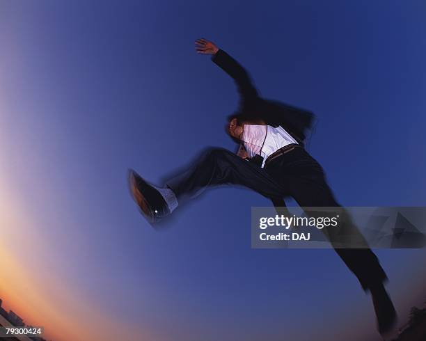 businessman jumping, low angle view, long exposure, copy space - mens long jump - fotografias e filmes do acervo