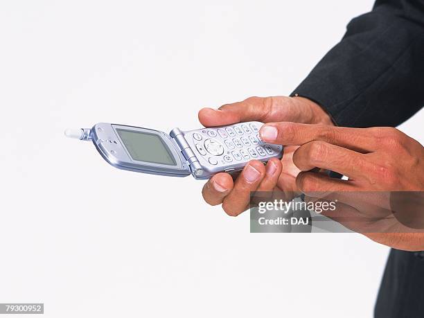 businessman pushing buttons of mobile phone, high angle view - male belly button 個照片及圖片檔