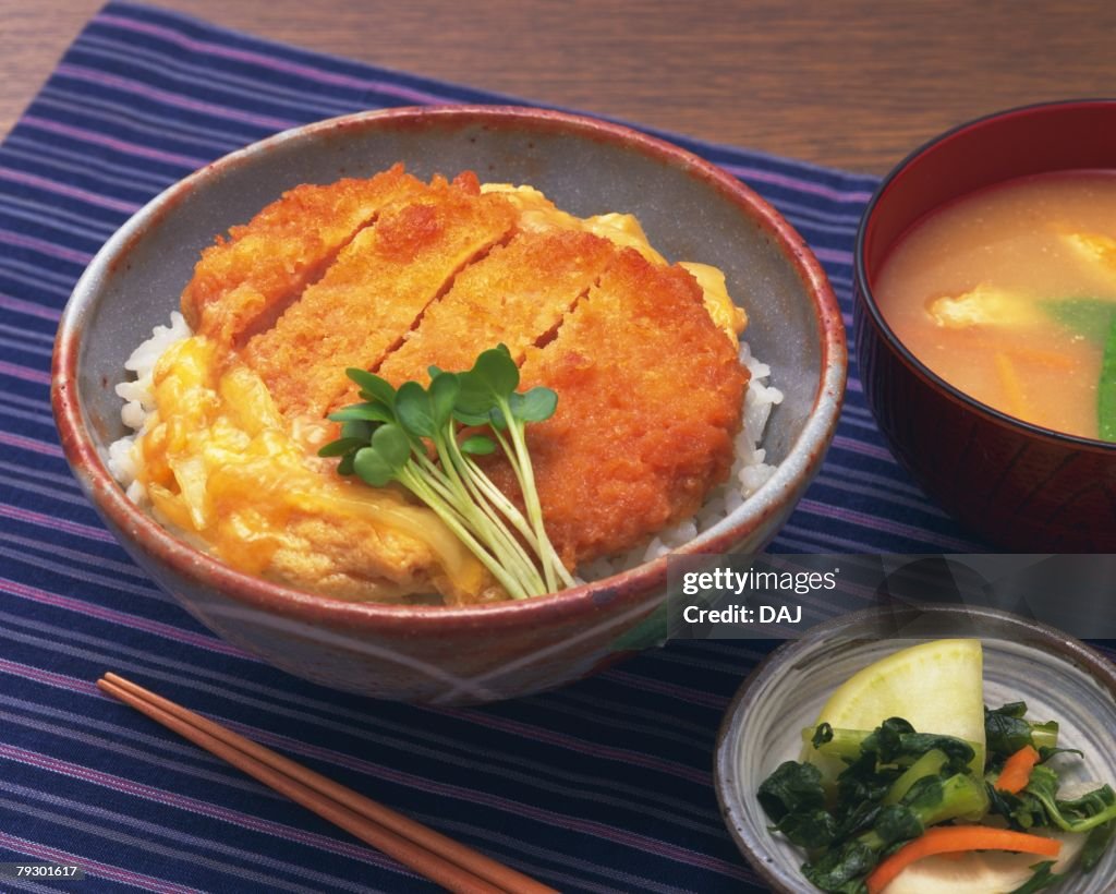 Pork cutlet on rice in bowl, high angle view
