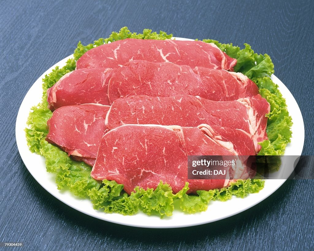 Raw beef on salad, high angle view