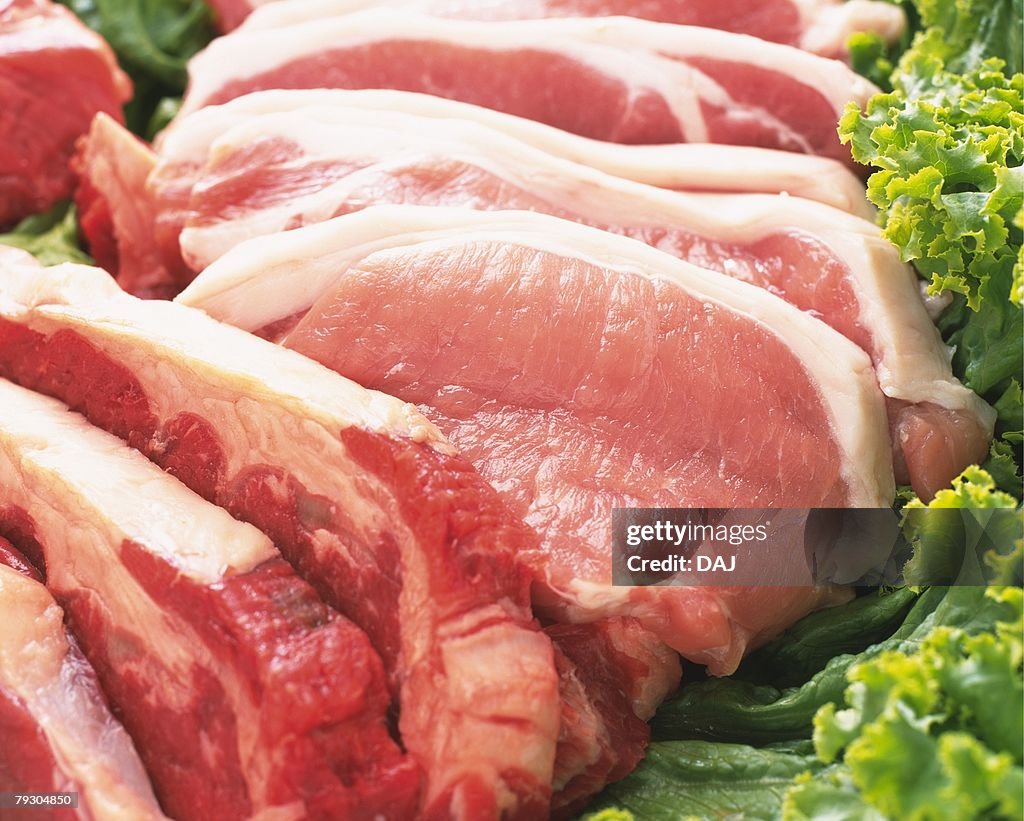 Raw pork (Loin) with green leaves, high angle view, close up