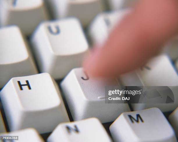 a finger pressing a keyboard, close up, high angle view, blurred motion - computer key stock pictures, royalty-free photos & images