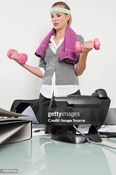 employé de bureau à l'aide d'haltères - bandeau anti transpiration photos et images de collection