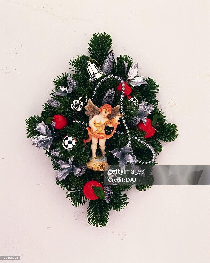 Christmas wreath with angel figurine, front view, white background