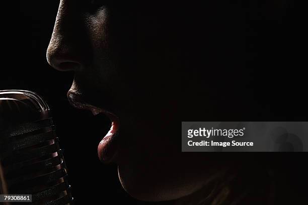 a woman singing - woman microphone stock pictures, royalty-free photos & images