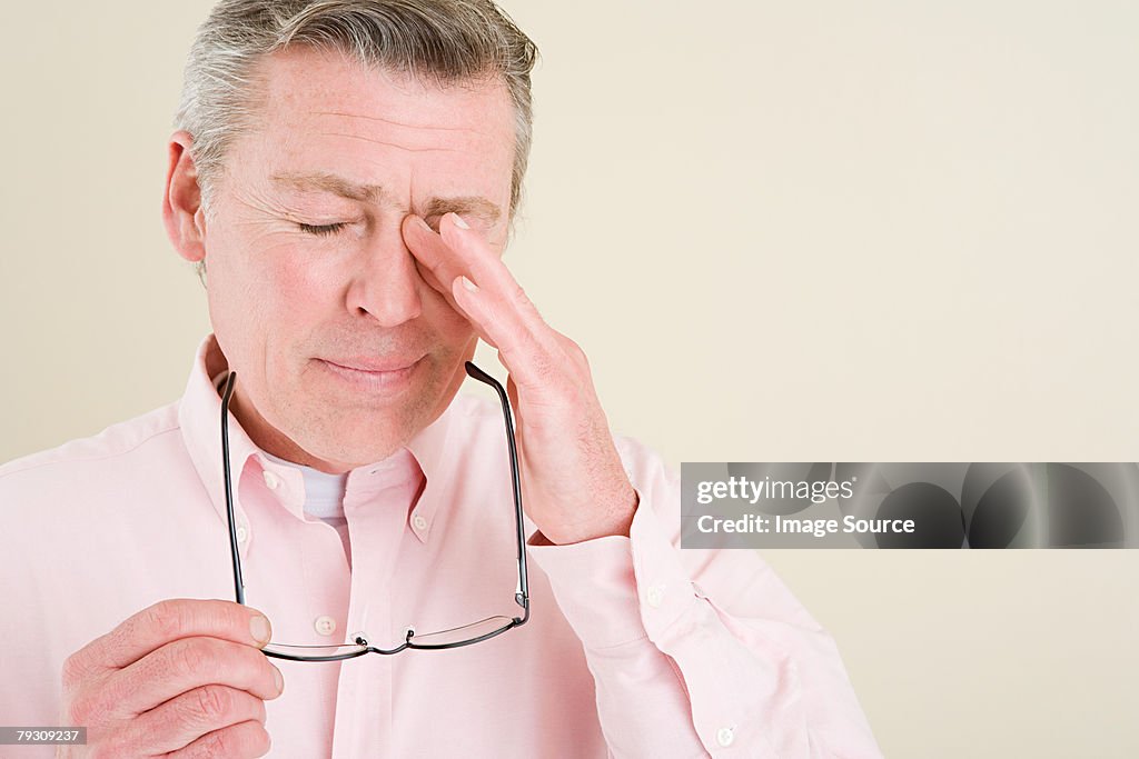 Um homem Coçar os Olhos