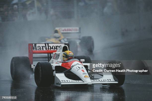 Ayrton Senna of Brazil drives the Honda Marlboro McLaren McLaren MP4-6 ahead of Nigel Mansell in the Canon Williams Renault Williams FW14 in the rain...