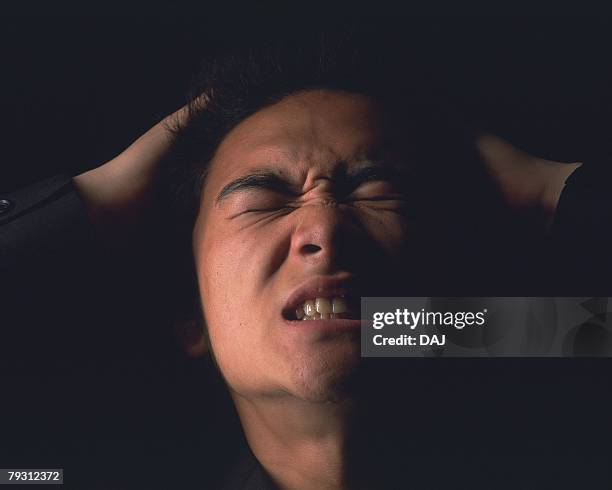 a businessman struggling and tearing out hair, close up, front view - tearing your hair out photos et images de collection