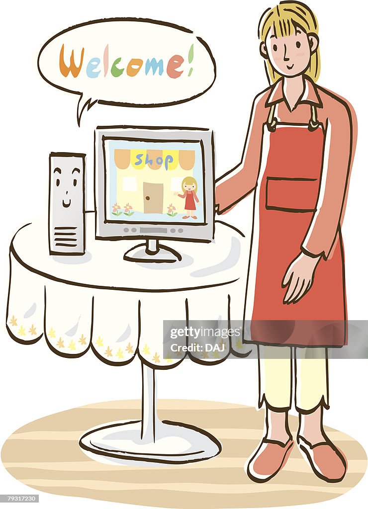 Woman standing beside table with computer, front view