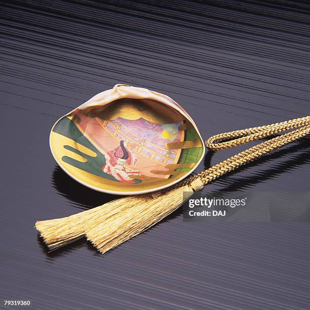 a painted seashell and a tied rope, high angle view, close up - muschel close up studioaufnahme stock-fotos und bilder