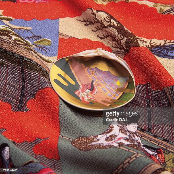 a painted seashell on a japanese patterned cloth, high angle view, close up - muschel close up studioaufnahme stock-fotos und bilder