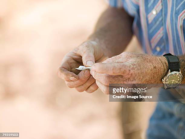 man rolling a cigarette - liver spot 個照片及圖片檔