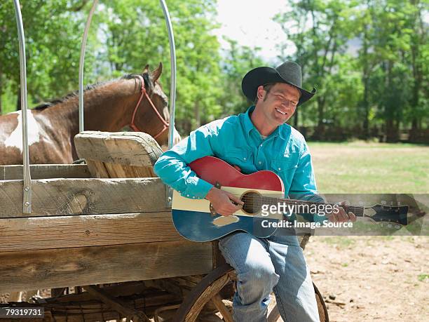 cowboy with a guitar - country and western music stock pictures, royalty-free photos & images
