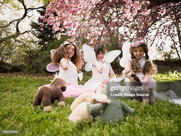 friends casting spells on their soft toys - fee stockfoto's en -beelden