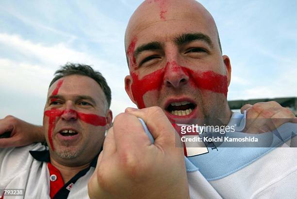Fans of England's soccer team have their face painted to resemble England's national flag in front of the Shizuoka Stadium before the 2002 World Cup...