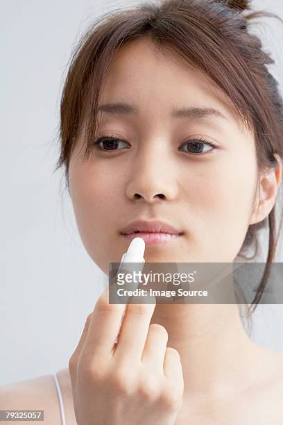 japanische frau benutzt lippenstift - lip balm stock-fotos und bilder