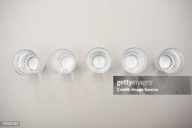 glasses of mineral water in a row - shot glass stock-fotos und bilder