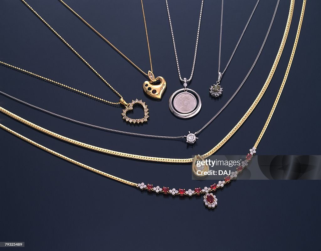 Various necklaces with jewels, high angle view, black background