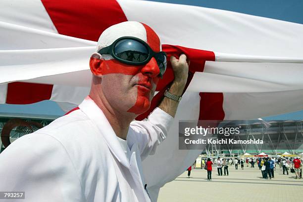 Fan of England's soccer team holds the national flag in front of the Shizuoka Stadium before the 2002 World Cup match between England and Brazil June...