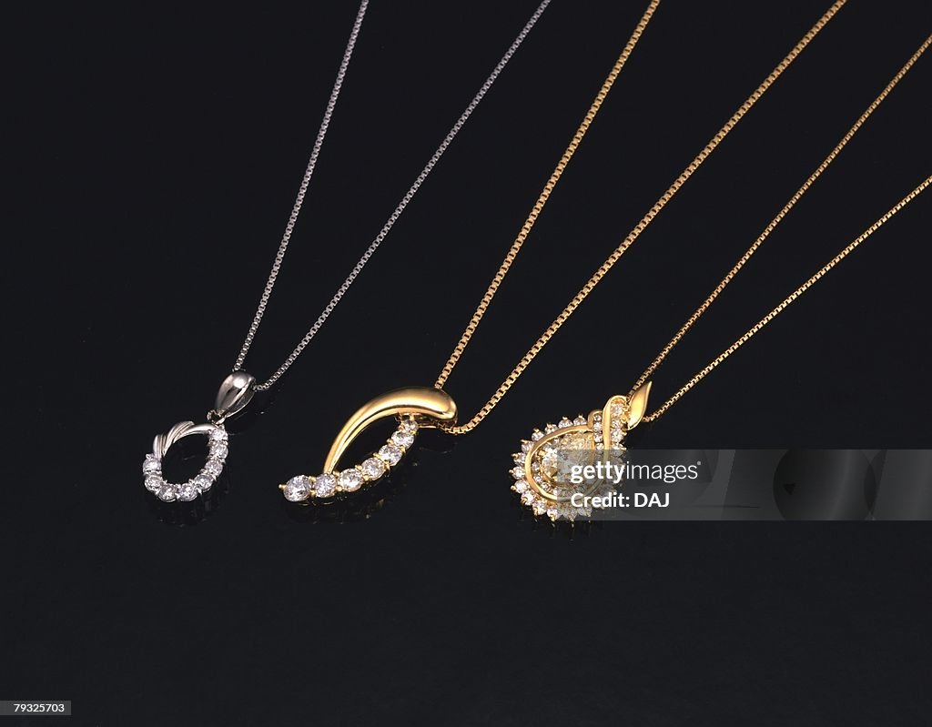 Three necklaces with jewels, high angle view, black background