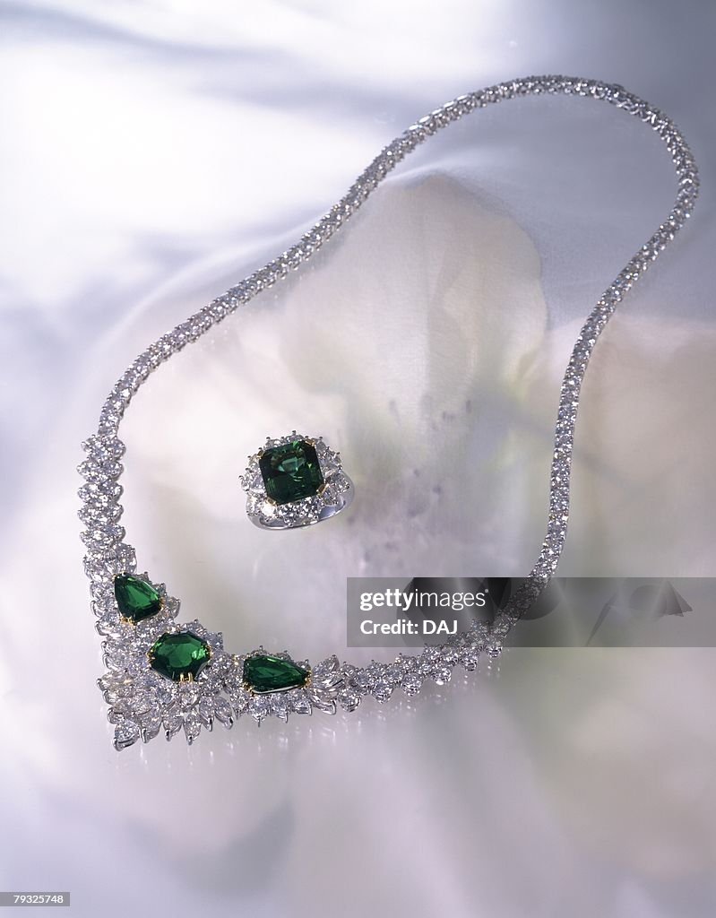 Diamond ring and necklace with jewels, image of flower, high angle view