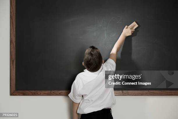 boy cleaning blackboard - rubbing stock pictures, royalty-free photos & images