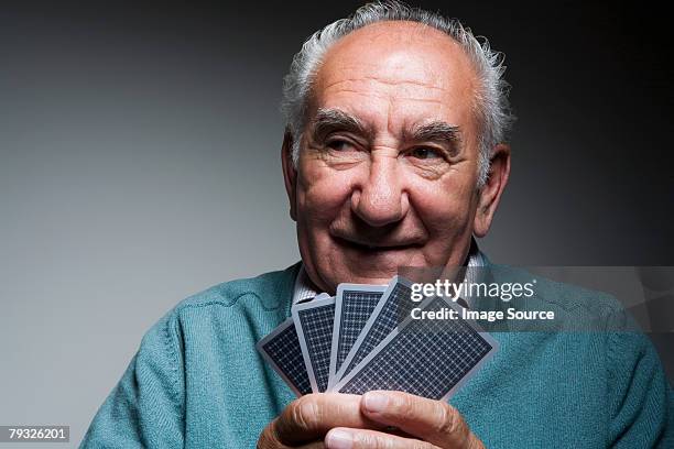 senior man playing cards - one senior man only stock pictures, royalty-free photos & images