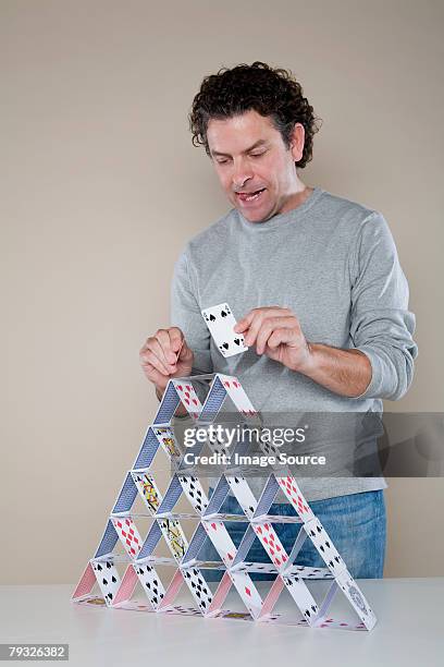 man making a house of cards - card house stock pictures, royalty-free photos & images