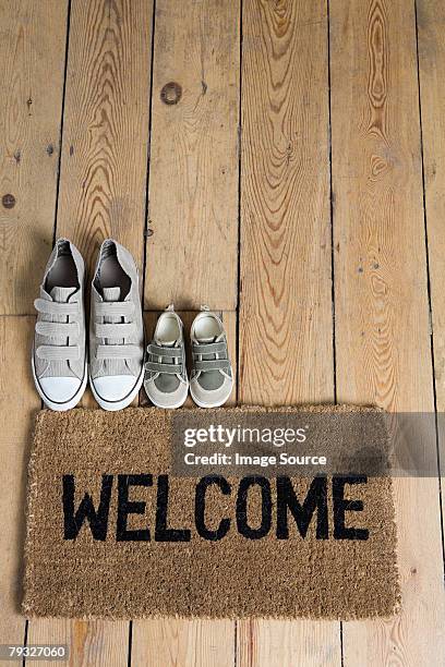 training shoes and a welcome mat - doormat stock pictures, royalty-free photos & images