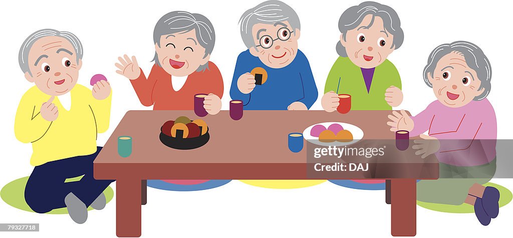 Senior people talking and sitting at table, enjoying tea time, high angle view