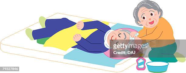 Senior Woman Washing Hair Of Senior Man Lying On Bed High Angle View  High-Res Vector Graphic - Getty Images