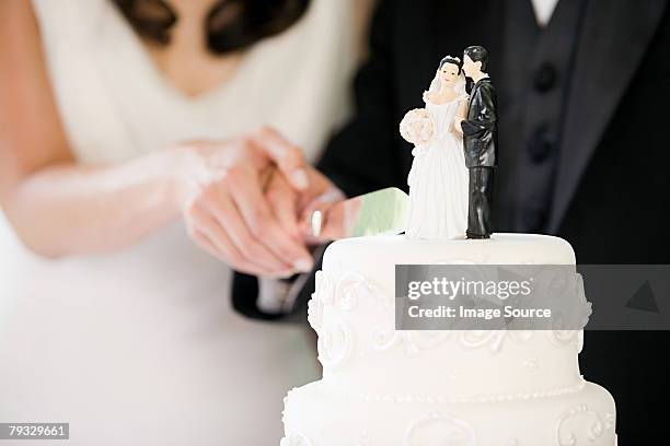 newlyweds cutting wedding cake - married stockfoto's en -beelden