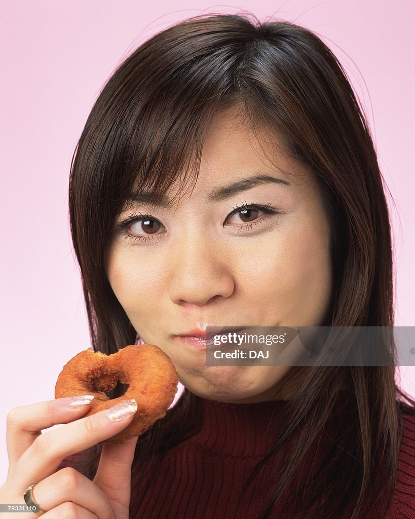 A Woman Eating Doughnut, Smiling, Looking at Camera, Front View