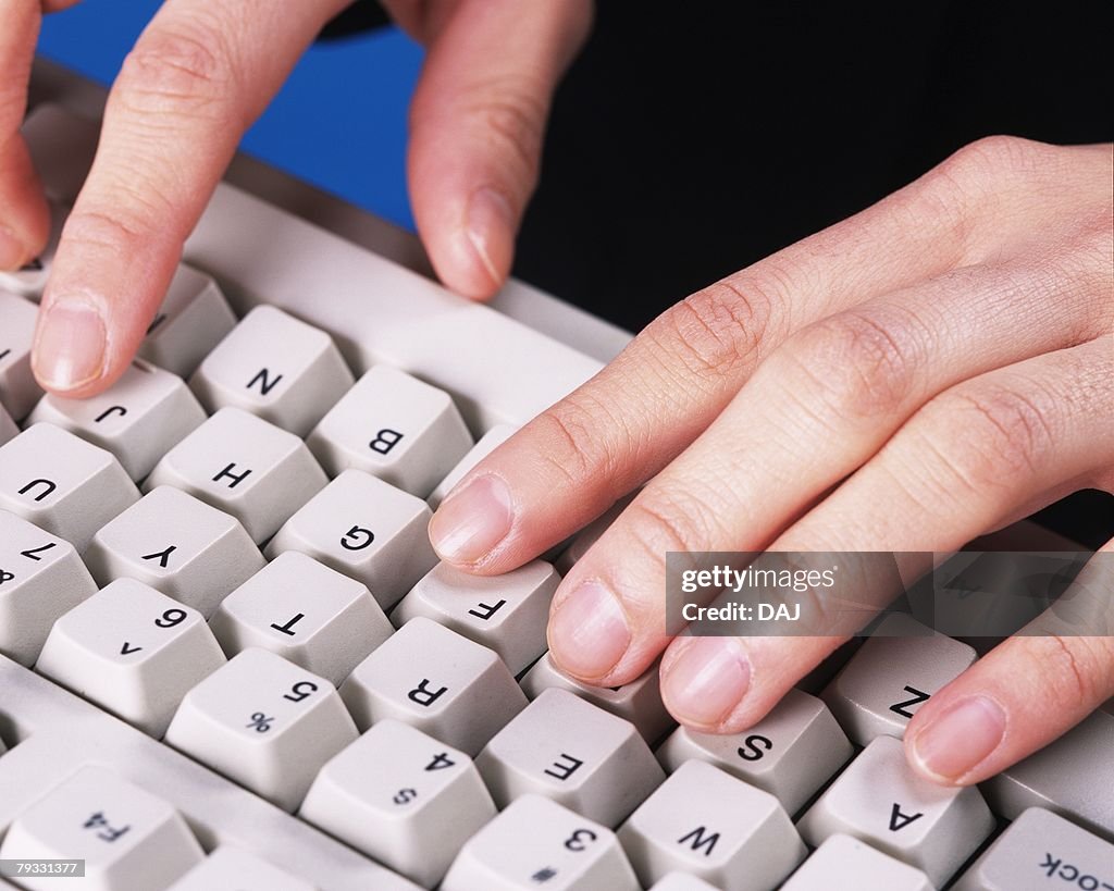 Photograph of hands typing computer keyboard, Close Up, Studio