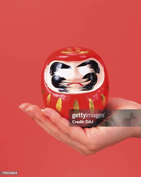 image of right hand holding a daruma, front view - daruma stock pictures, royalty-free photos & images