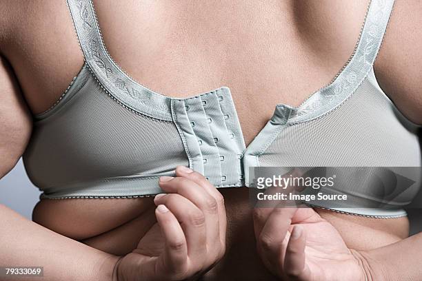 woman fastening bra - bra stock pictures, royalty-free photos & images