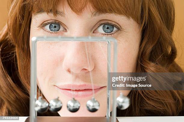 a woman and a newtons cradle - newtons cradle stockfoto's en -beelden