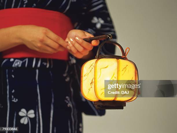 a woman in yukata holding a japanese lantern, close up - japanischer lampion stock-fotos und bilder