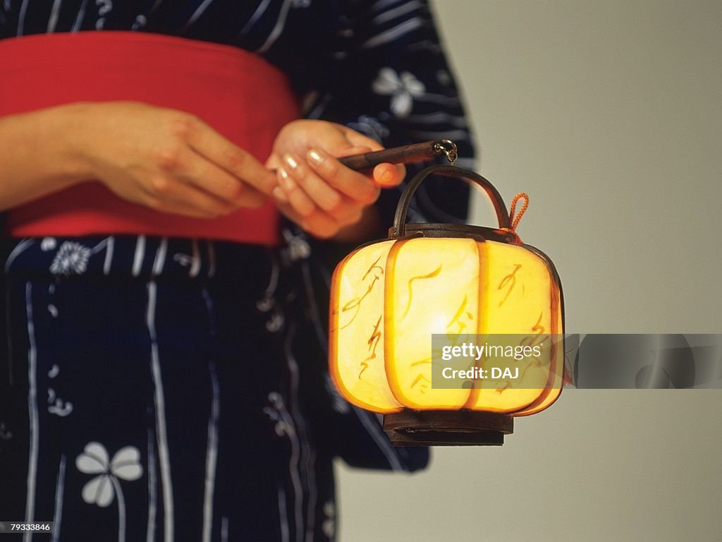 A woman in yukata holding a Japanese lantern, Close Up