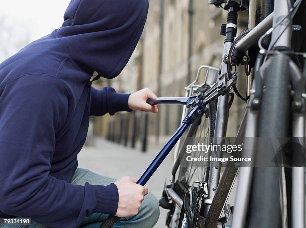 a thief stealing a bike - steel stockfoto's en -beelden