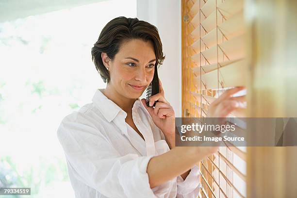 woman on telephone - window blind stock pictures, royalty-free photos & images