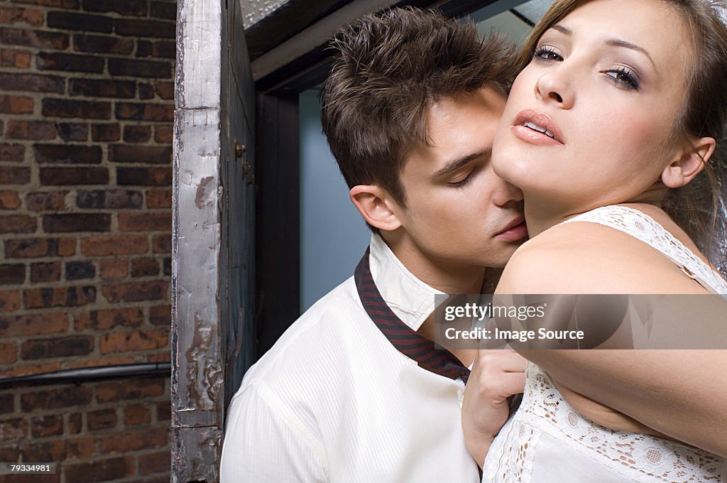 A man kissing a woman on the neck