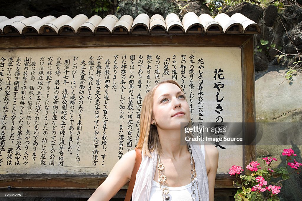 Woman standing near a japanese sign