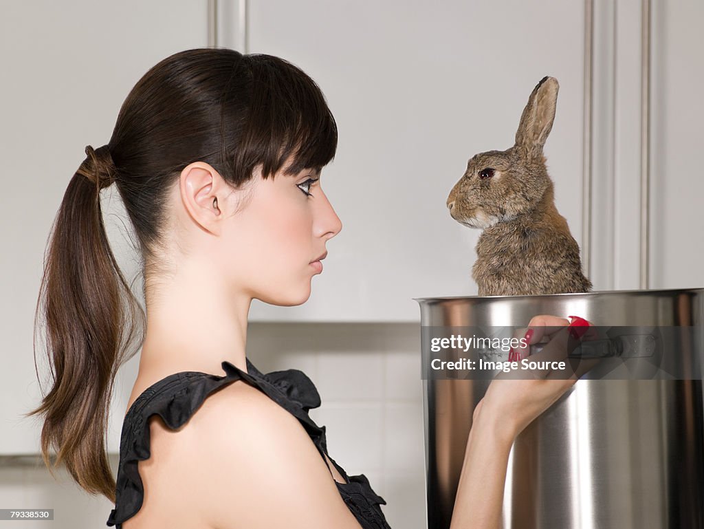 Woman holding a rabbit in a saucepan