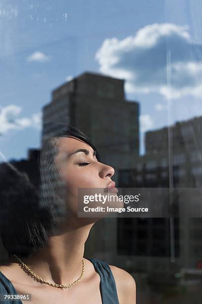 young woman by window - person of color stock pictures, royalty-free photos & images