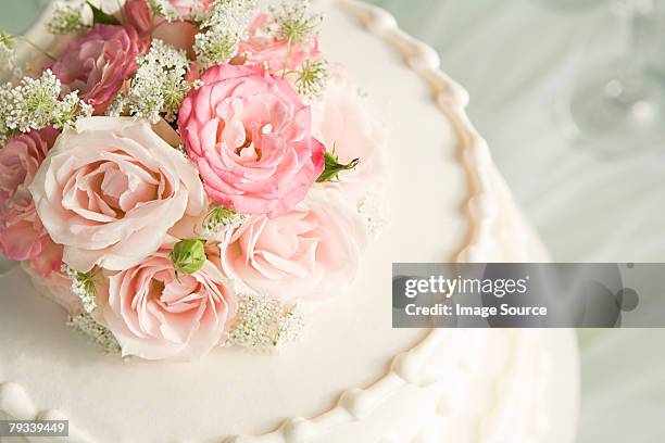 roses on top of a wedding cake - hochzeitstorte stock-fotos und bilder