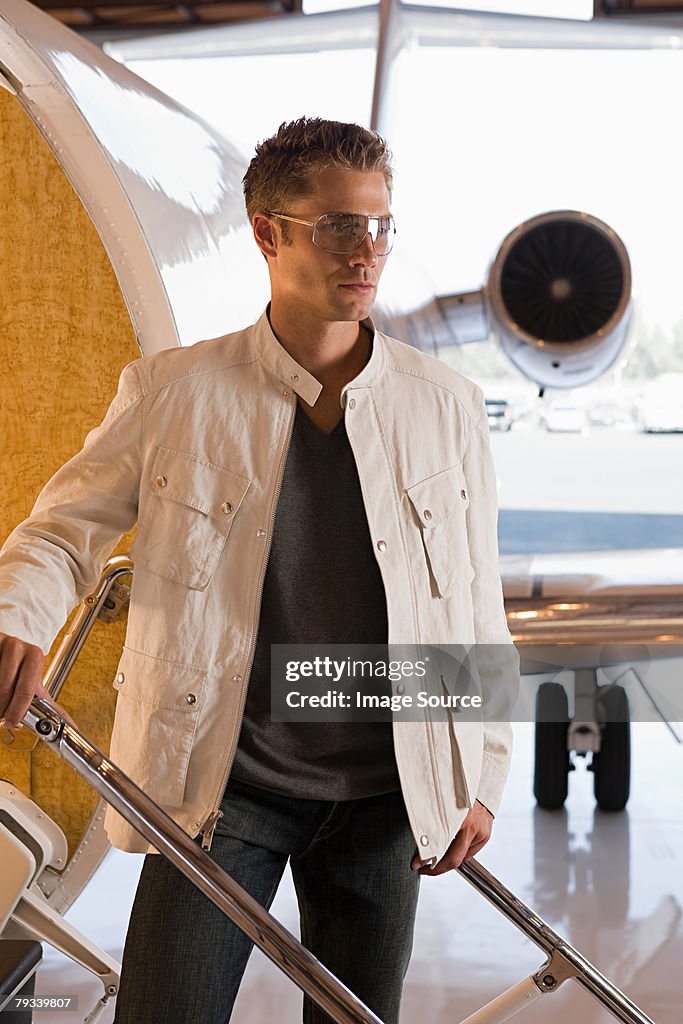 Young man by private airplane