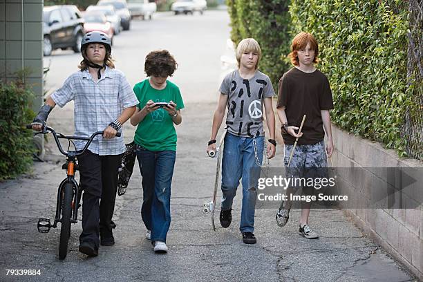 boys walking down a street - teenager cycling helmet stock pictures, royalty-free photos & images