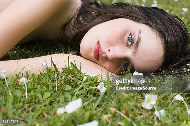 junge frau liegen auf gras - frühjahrsmüdigkeit frau stock-fotos und bilder