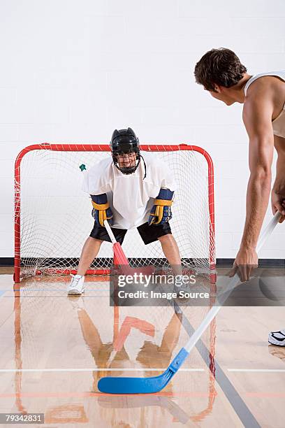 two men playing hockey - hockey net stock pictures, royalty-free photos & images